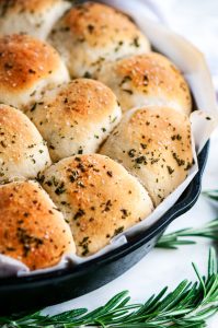 Rosemary Garlic Dinner Rolls in lodge cast iron skillet with parchment paper