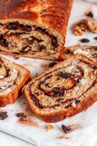 Cinnamon Raisin Swirl Bread sliced with butter on white marble close up