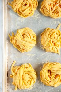 Homemade Pasta Dough Recipe nests on baking sheet