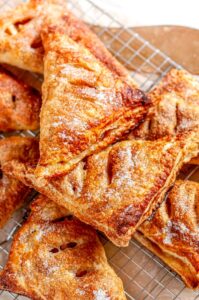 Puff Pastry Apple Turnovers on silver wire rack with white towel