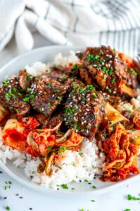 Instant Pot Korean Short Ribs on white plate with rice and kimchi