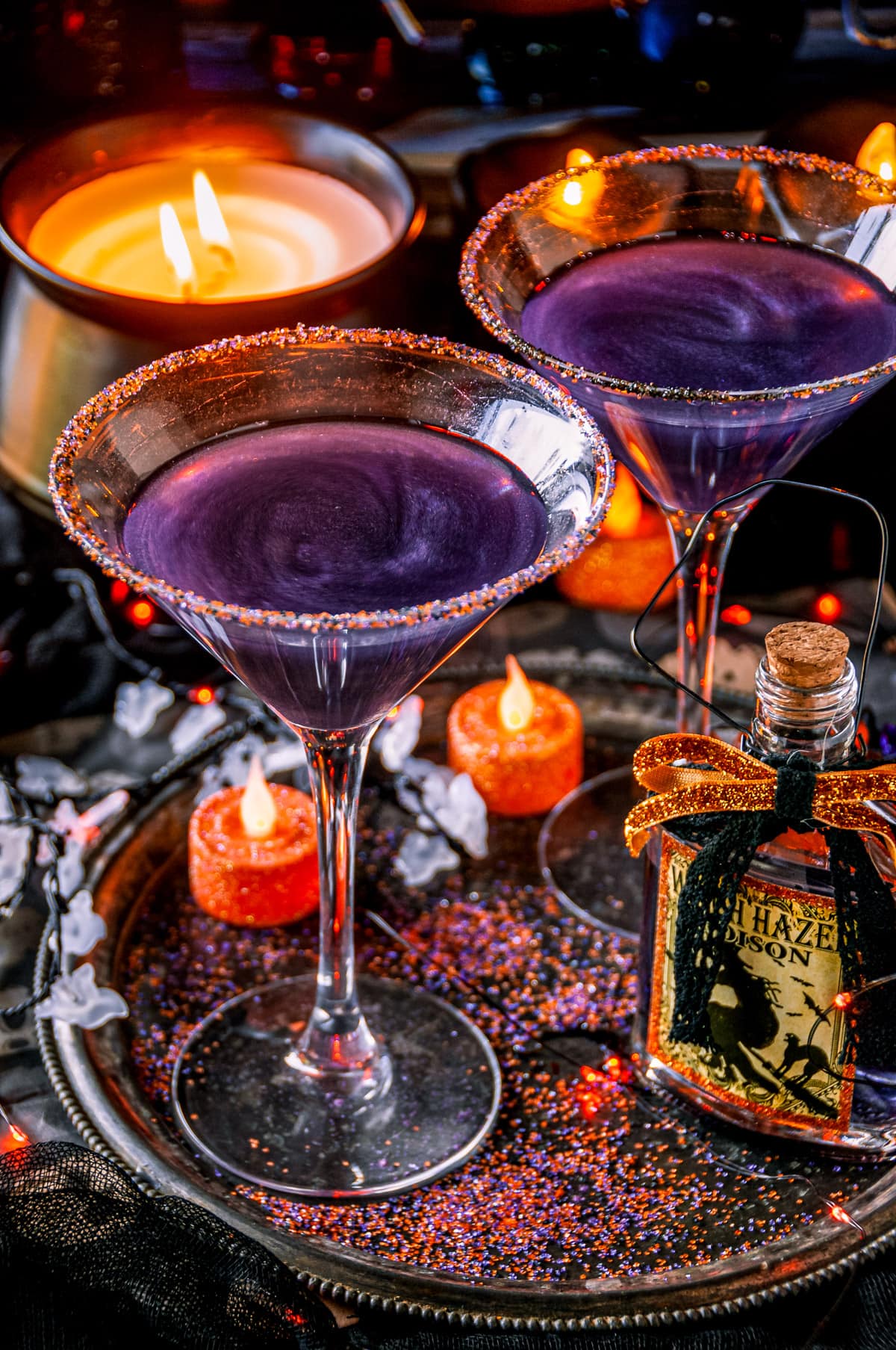 Halloween Hocus Pocus Cocktail in sugar rimmed martini glasses with candles in background
